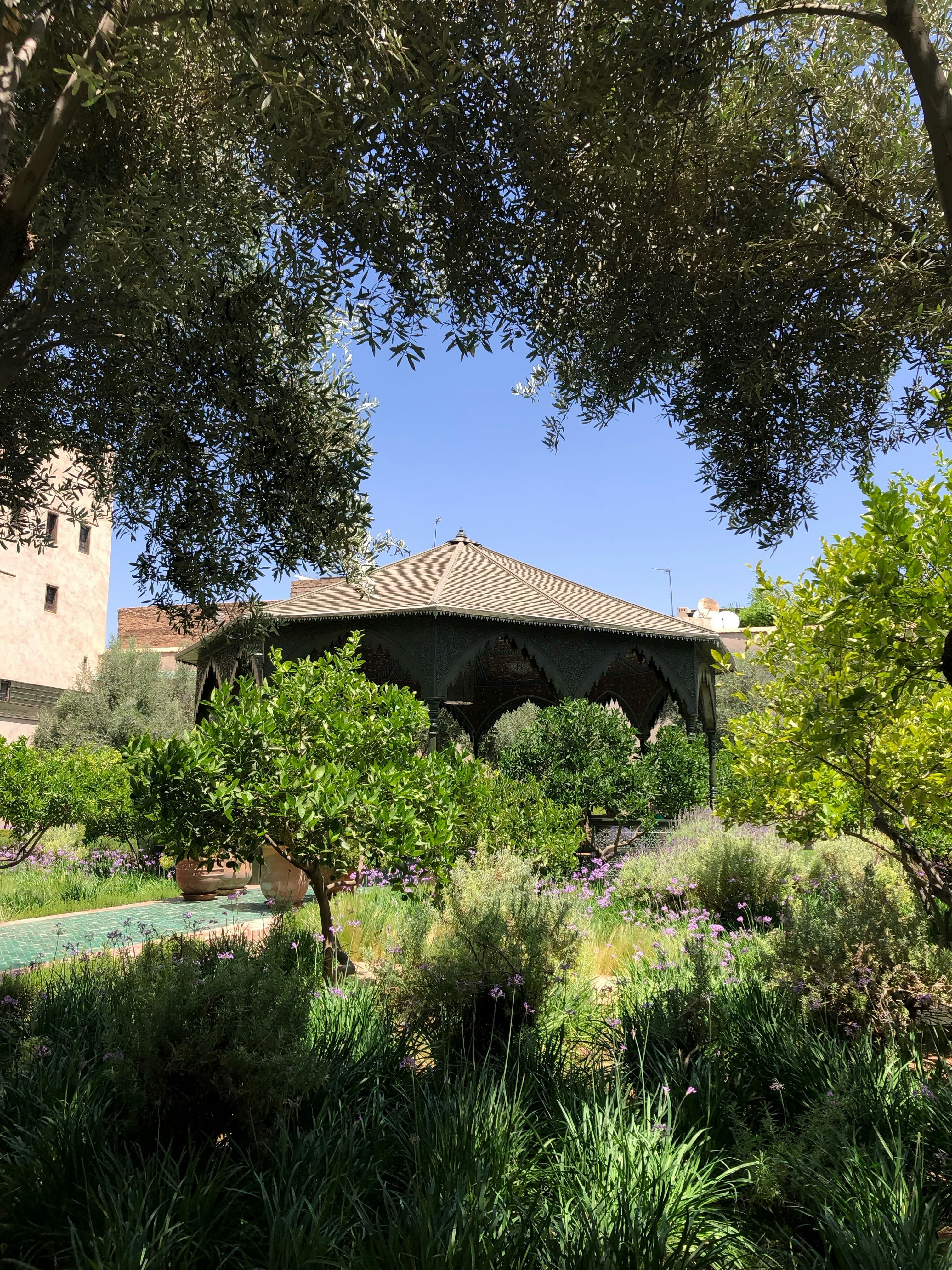 Outdoor pavilion surrounded by lush gardens