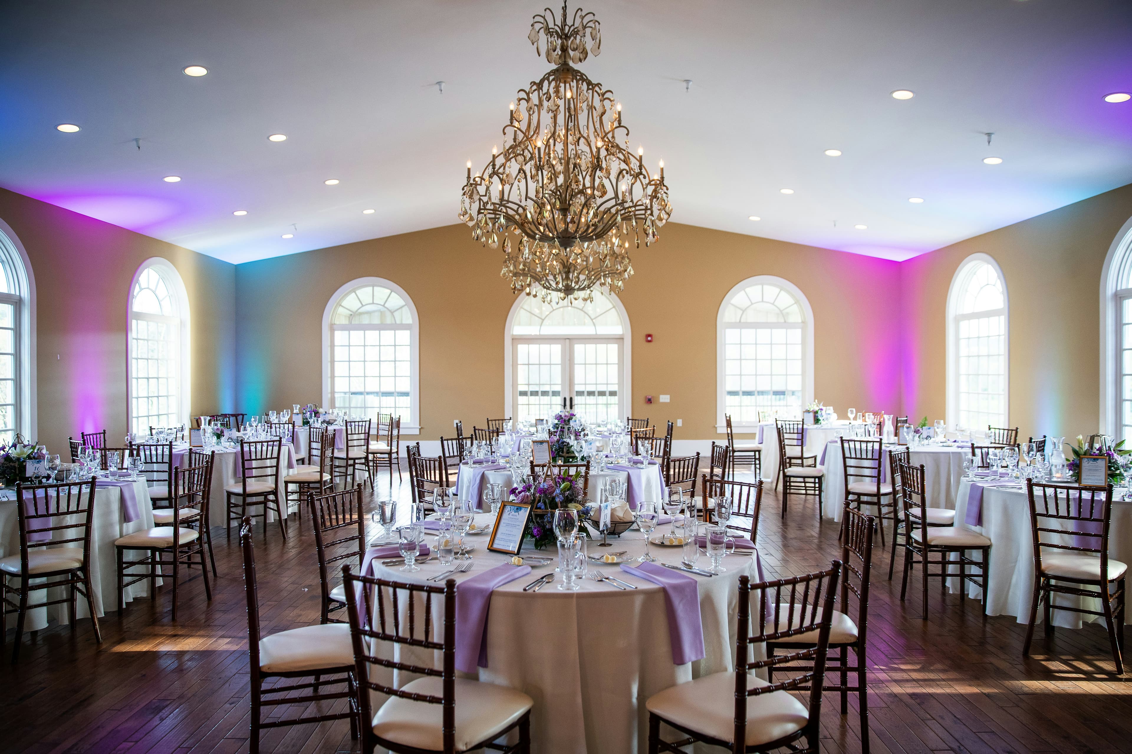 Elegant reception hall with round tables and warm ambient lighting