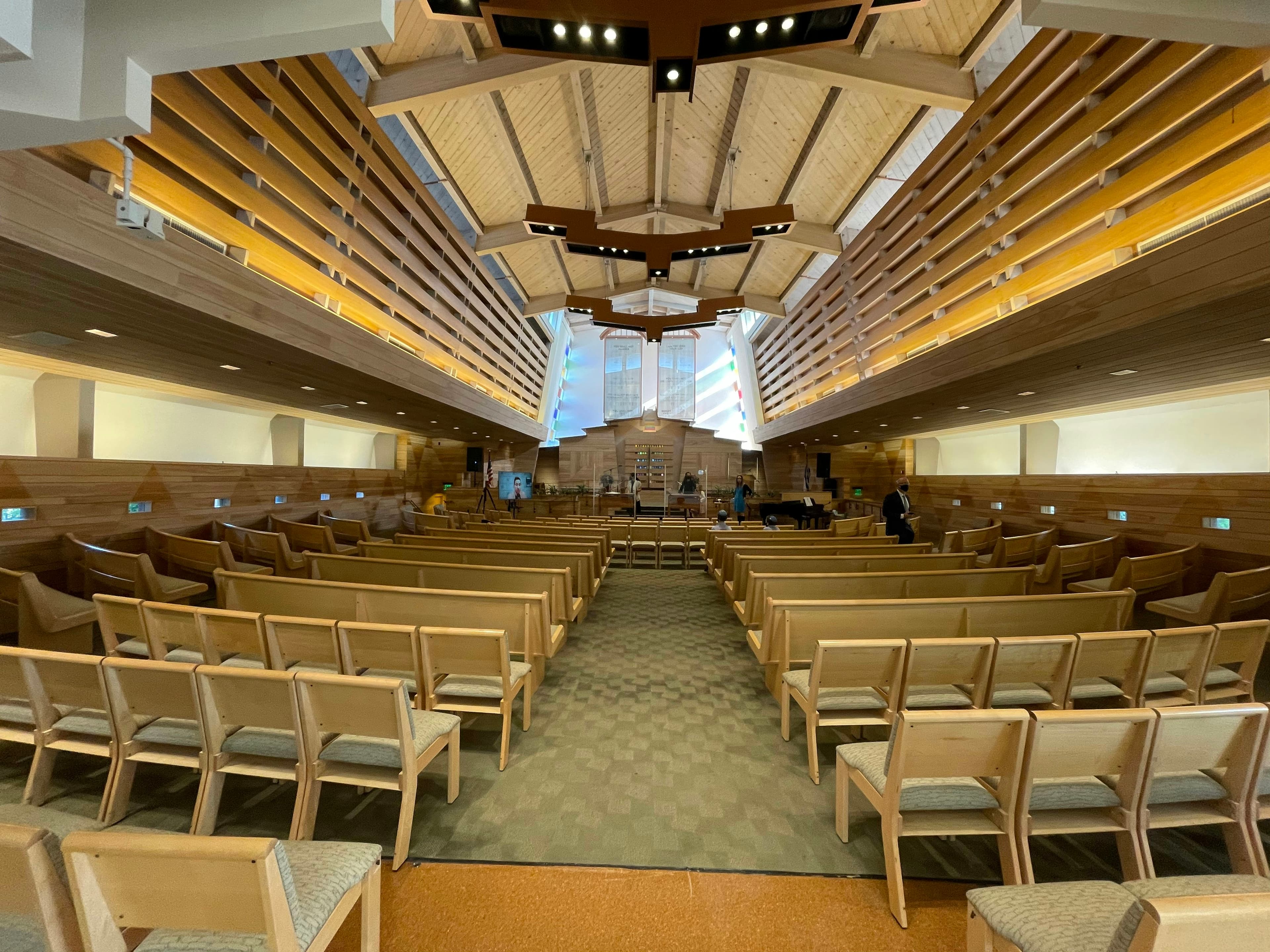 Spacious chapel interior with wooden pews and stained glass windows